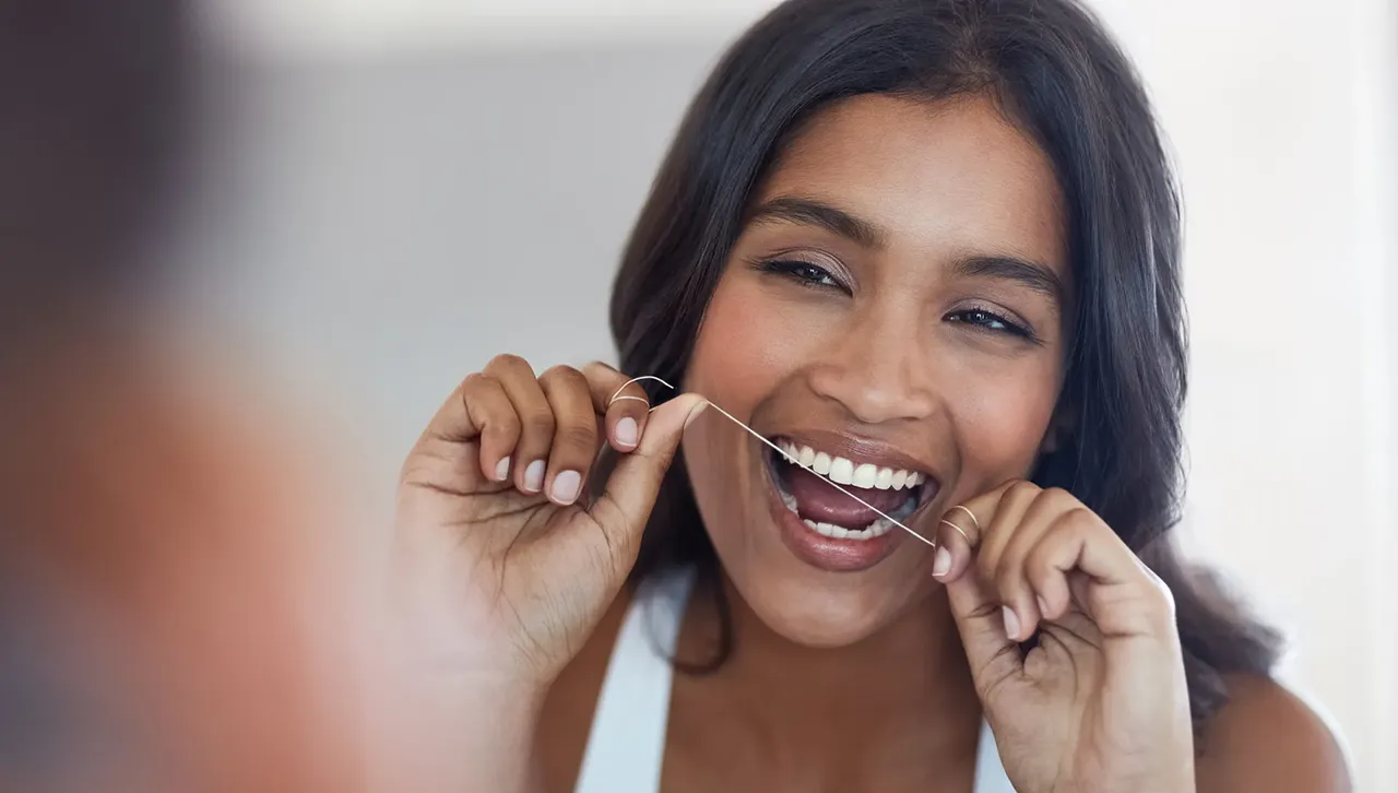 Woman Flossing While Practicing Good Oral Hygiene